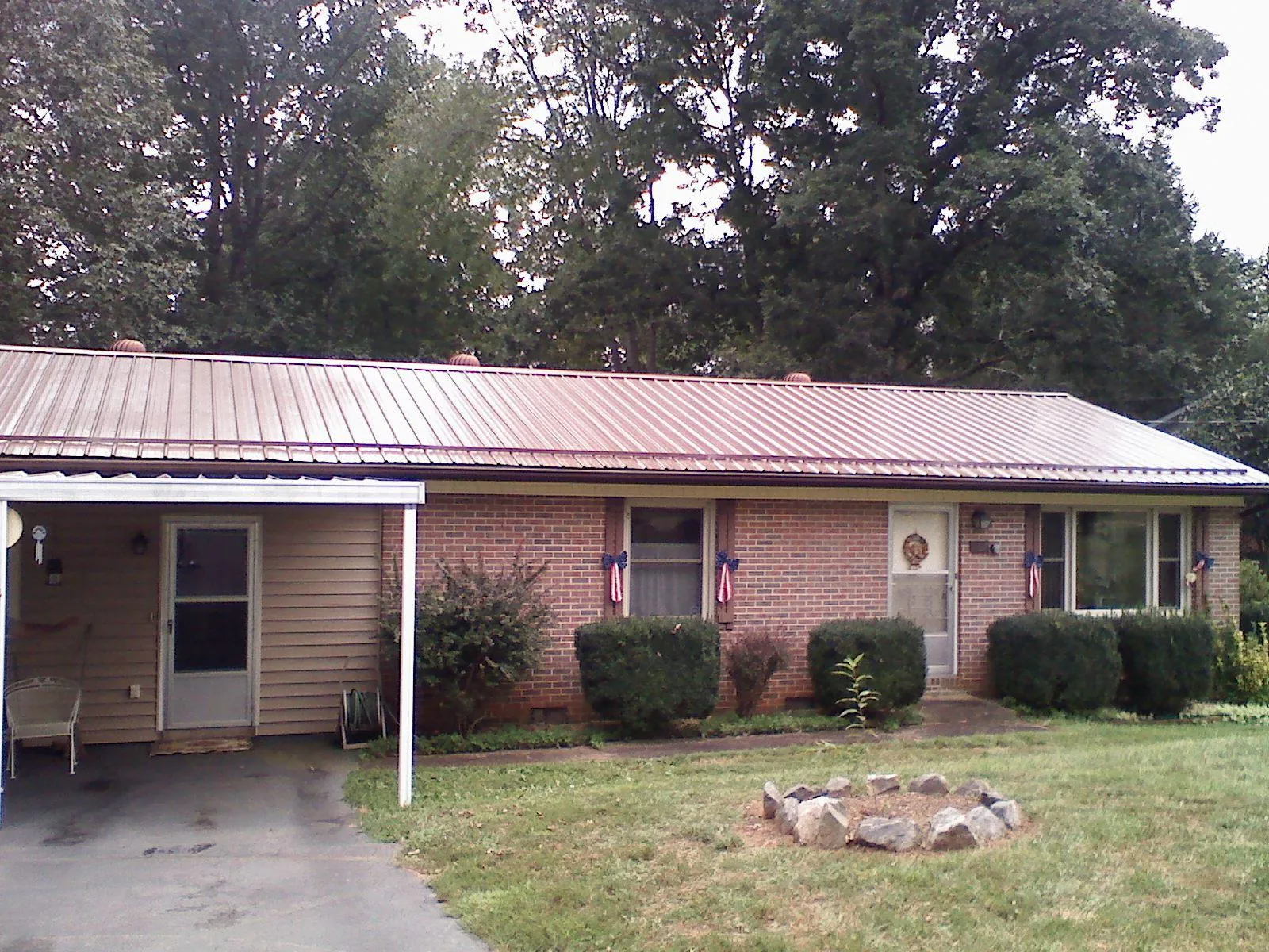 Bronze metal roof and carport on a brick ranch home — Roof Repair work by our crew in Mercer